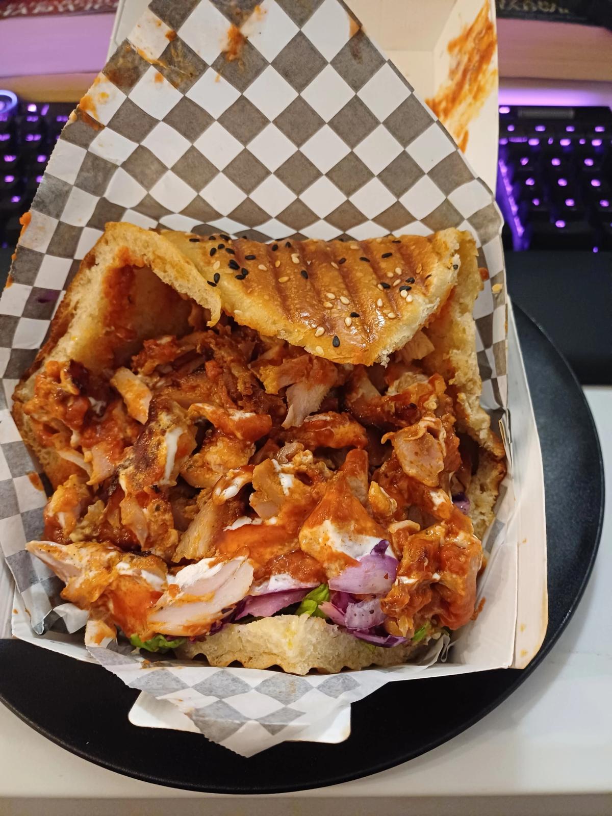 A packed pita sandwhich with juicy chicken and sauce