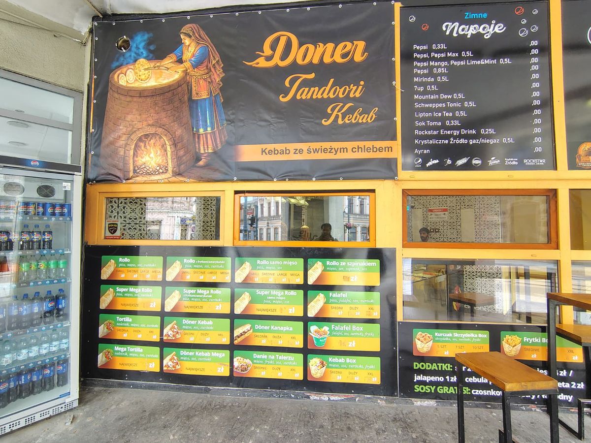 Street-facing storefront with prices and outdoor seating