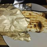 a medium size kebab wrapped in tinfoil paper