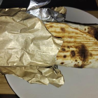 a medium size kebab wrapped in tinfoil paper