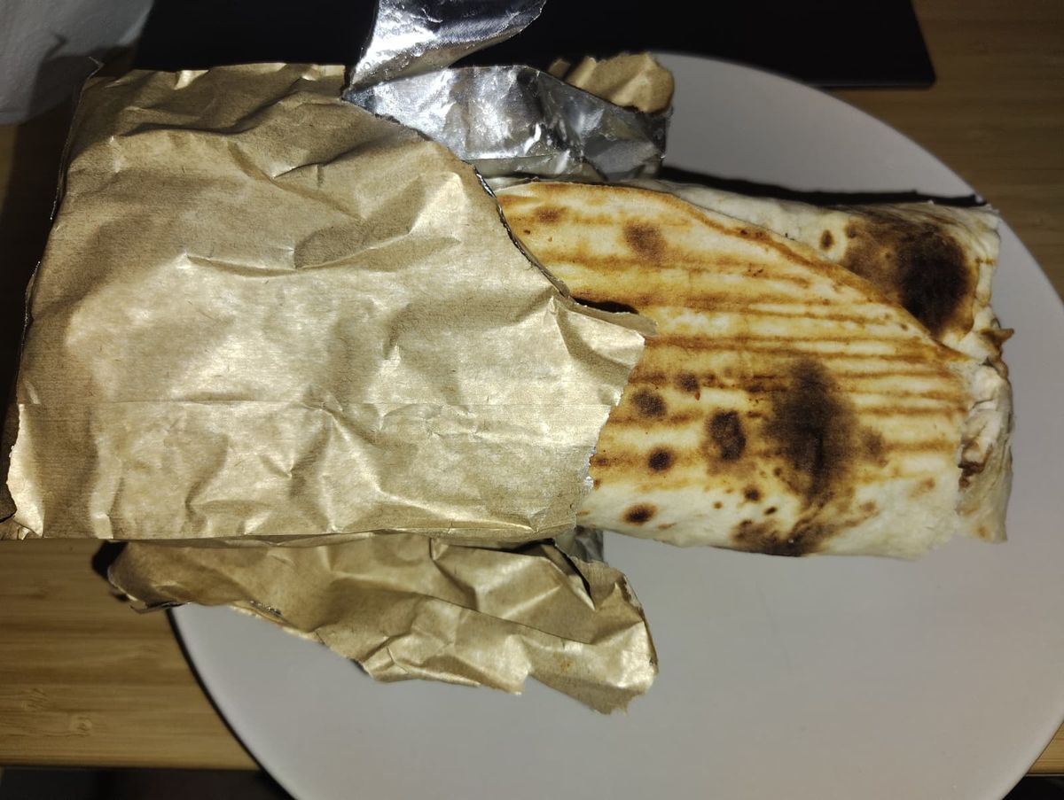 a medium size kebab wrapped in tinfoil paper