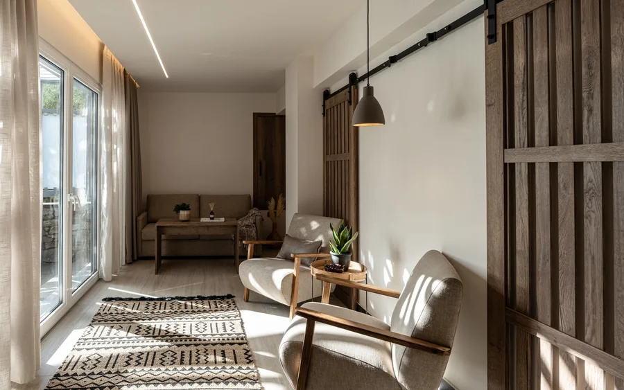Hotel suite living area with two armchairs, a patterned rug and a sliding barn door