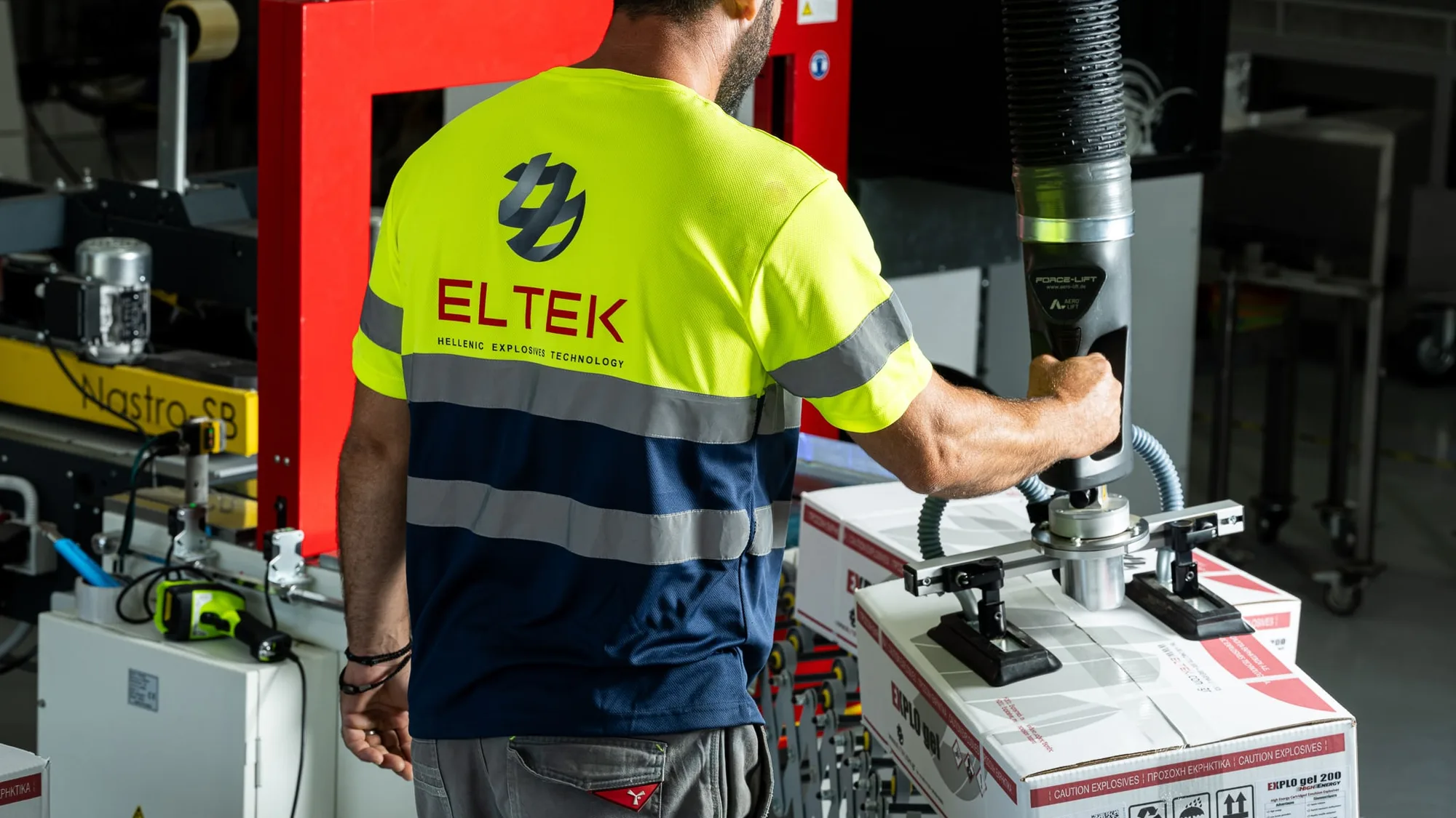 Technician in high-visibility workwear operating a packaging machine