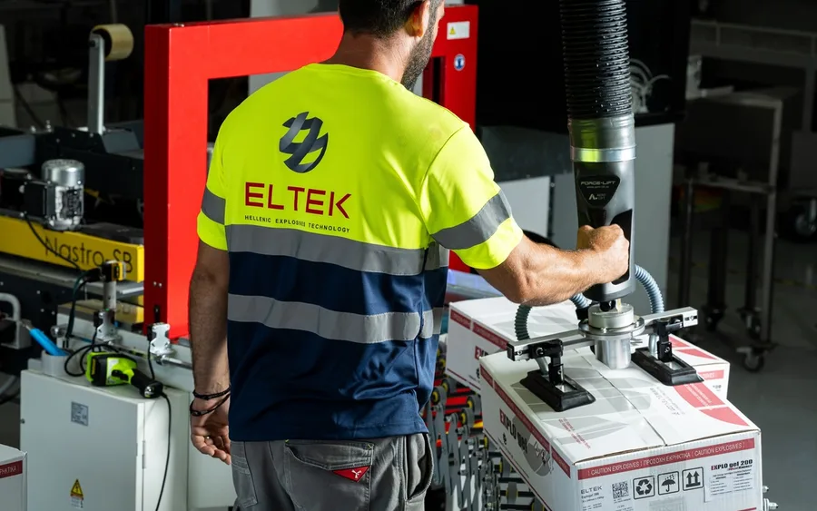 Technician in high-visibility workwear operating a packaging machine