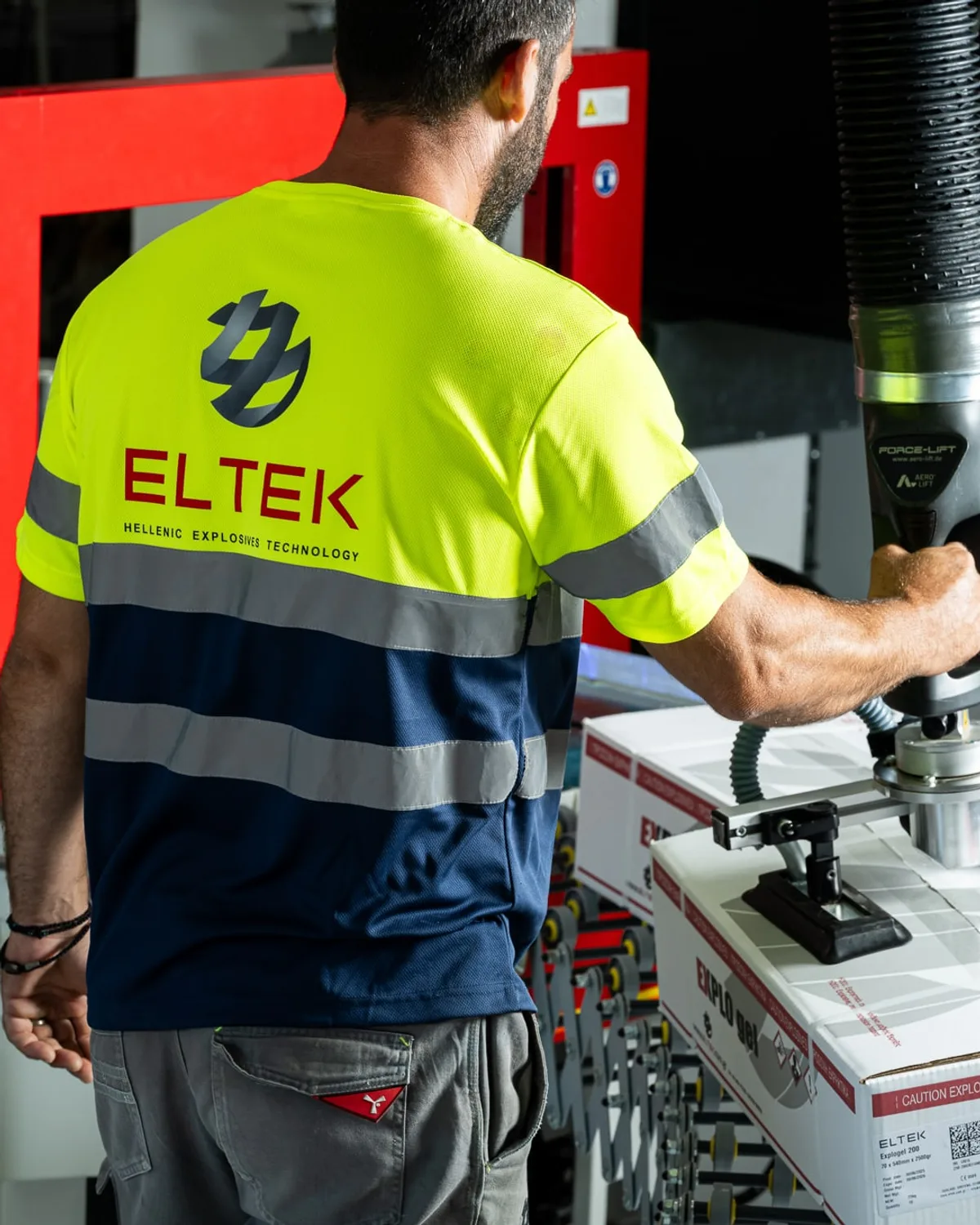 Technician in high-visibility workwear operating a packaging machine