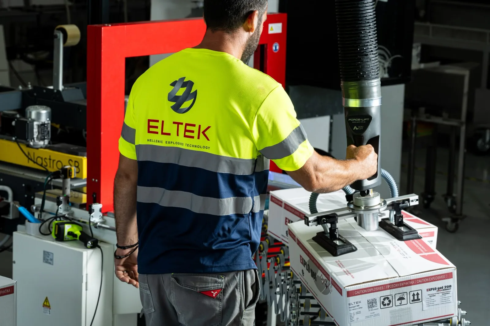 Technician in high-visibility workwear operating a packaging machine