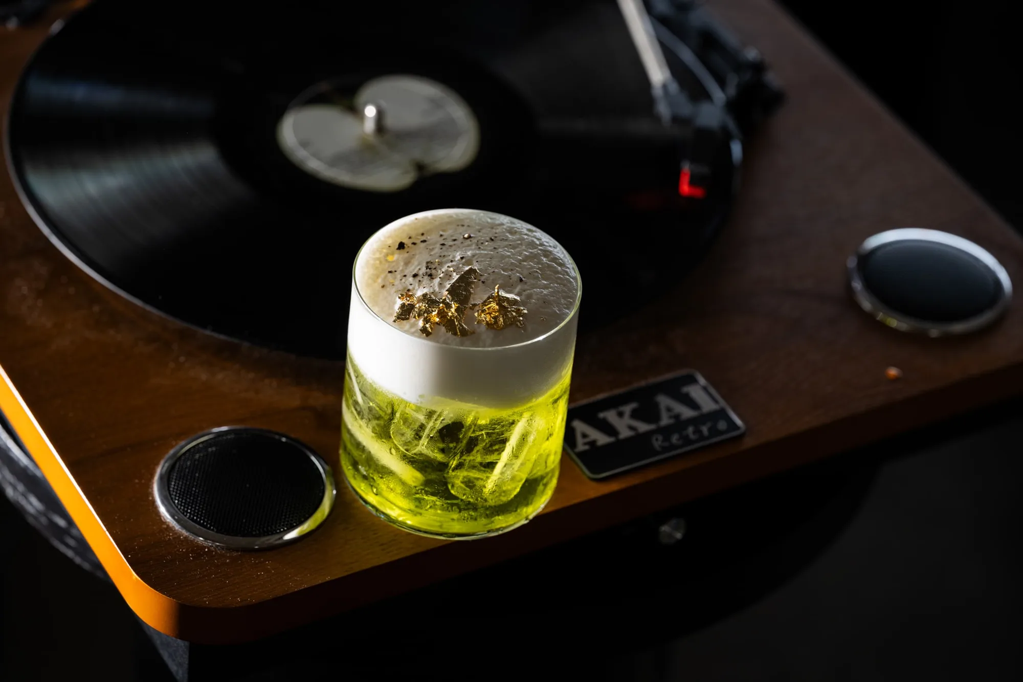 Cocktail resting on a turntable in a dim bar