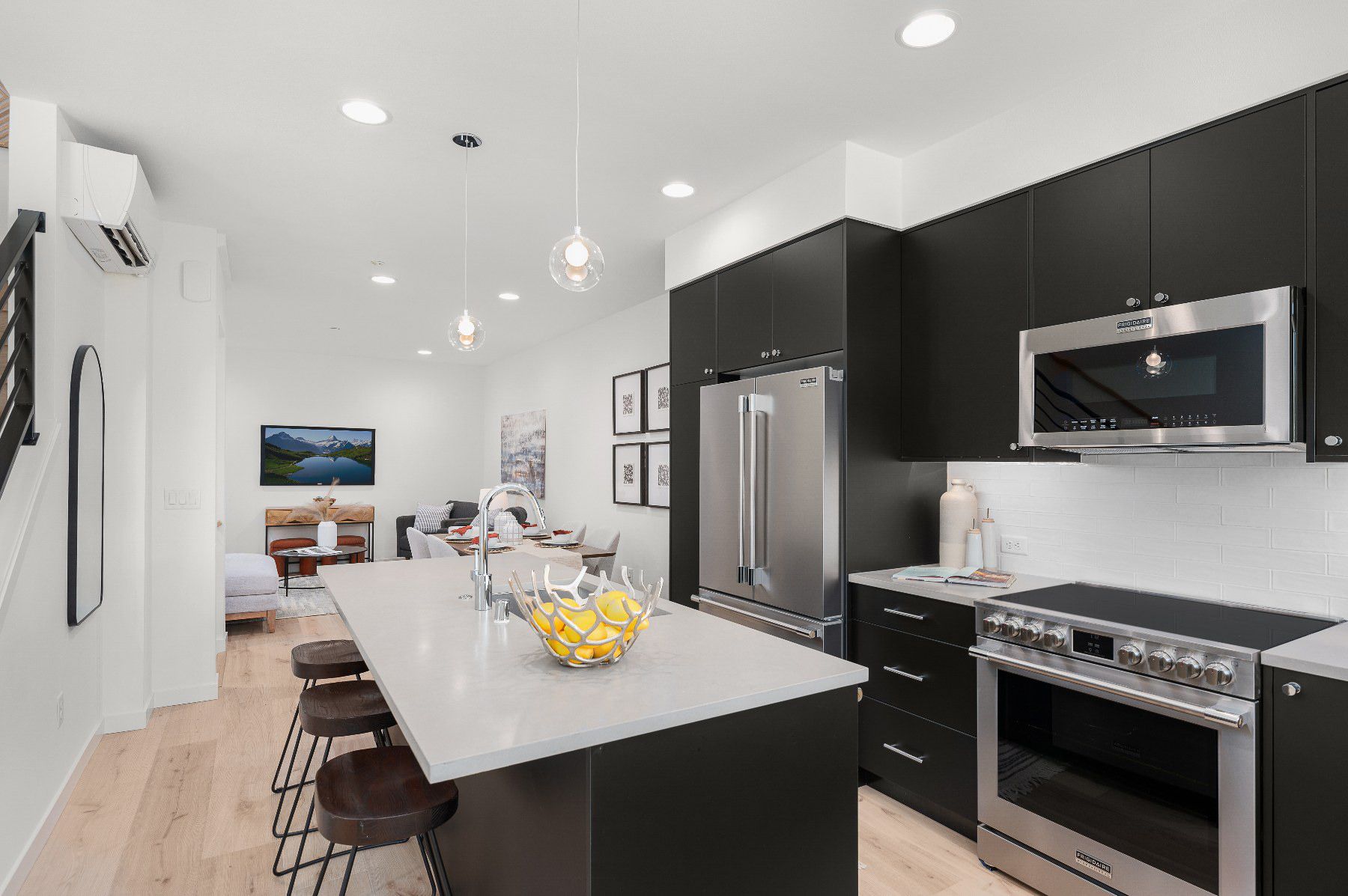 Chef's kitchen with a quartz island, full-height cabinetry, and the stair beyond