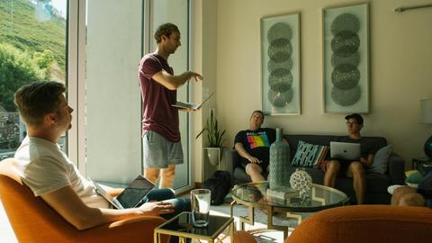 Group of men having a relaxed meeting in a bright, modern living room.