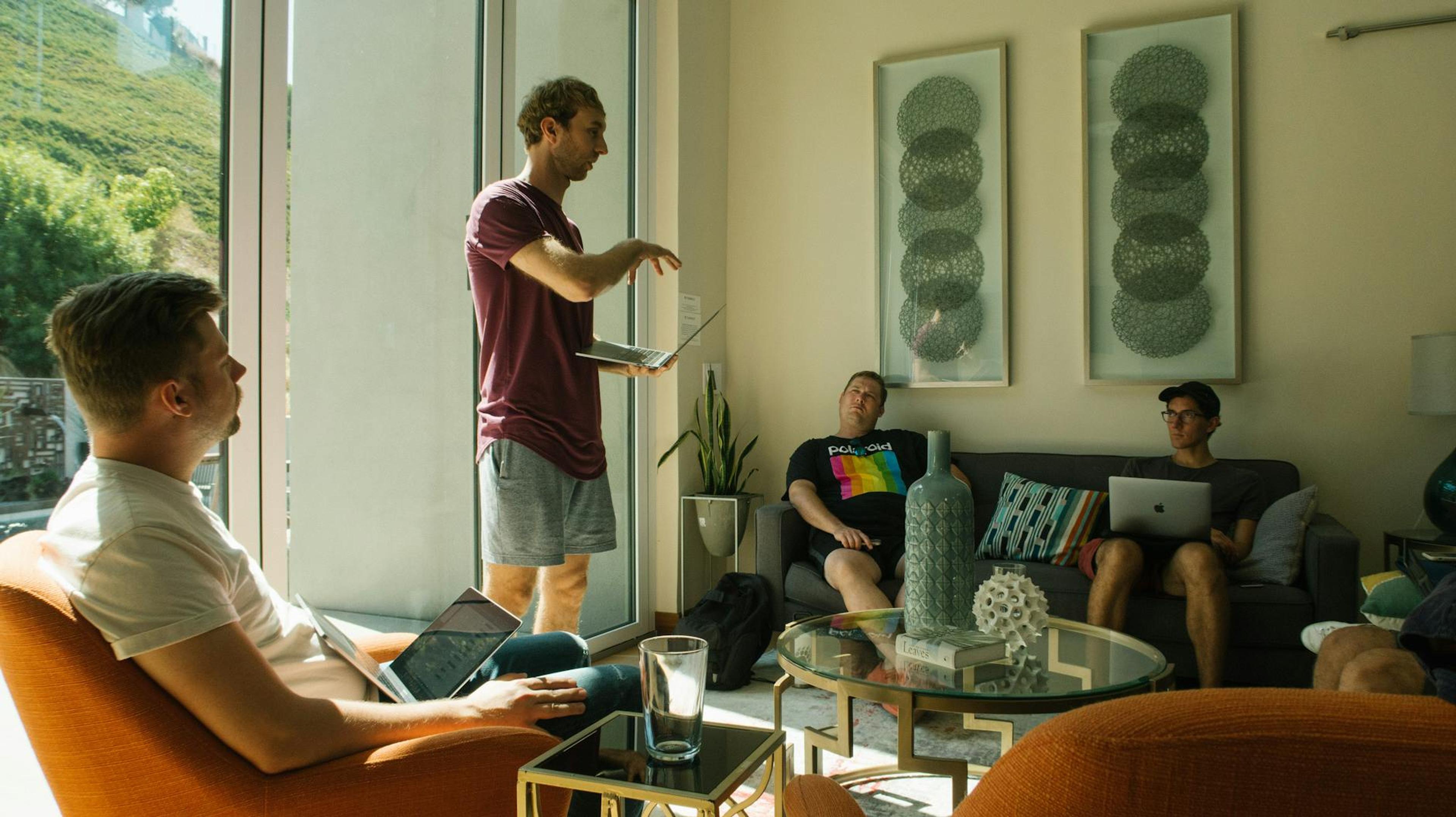 Group of men having a relaxed meeting in a bright, modern living room.