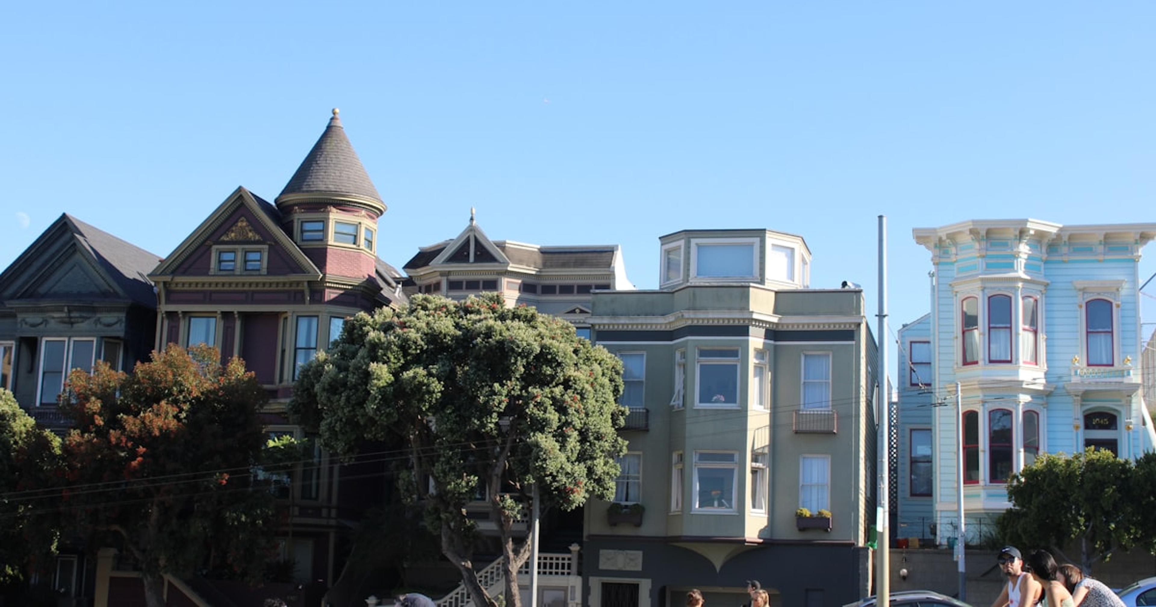 a group of people sitting on the grass in front of a building