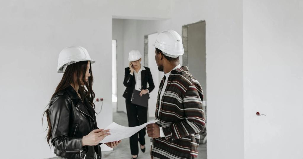 Diverse construction team in hard hats reviewing blueprints inside a building project.