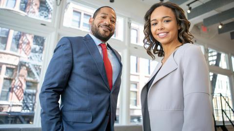 Business professionals smiling in a modern Detroit office setting.