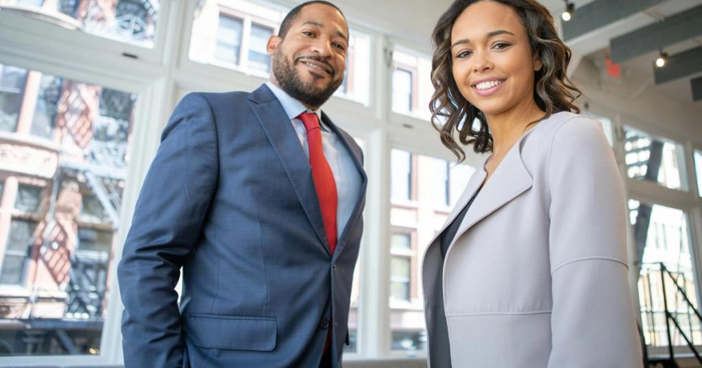 Business professionals smiling in a modern Detroit office setting.