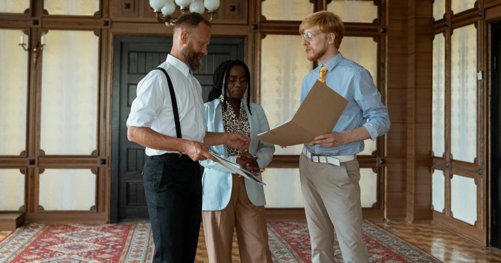 Three business professionals engaged in a discussion in a vintage office setting, showcasing teamwork and collaboration.