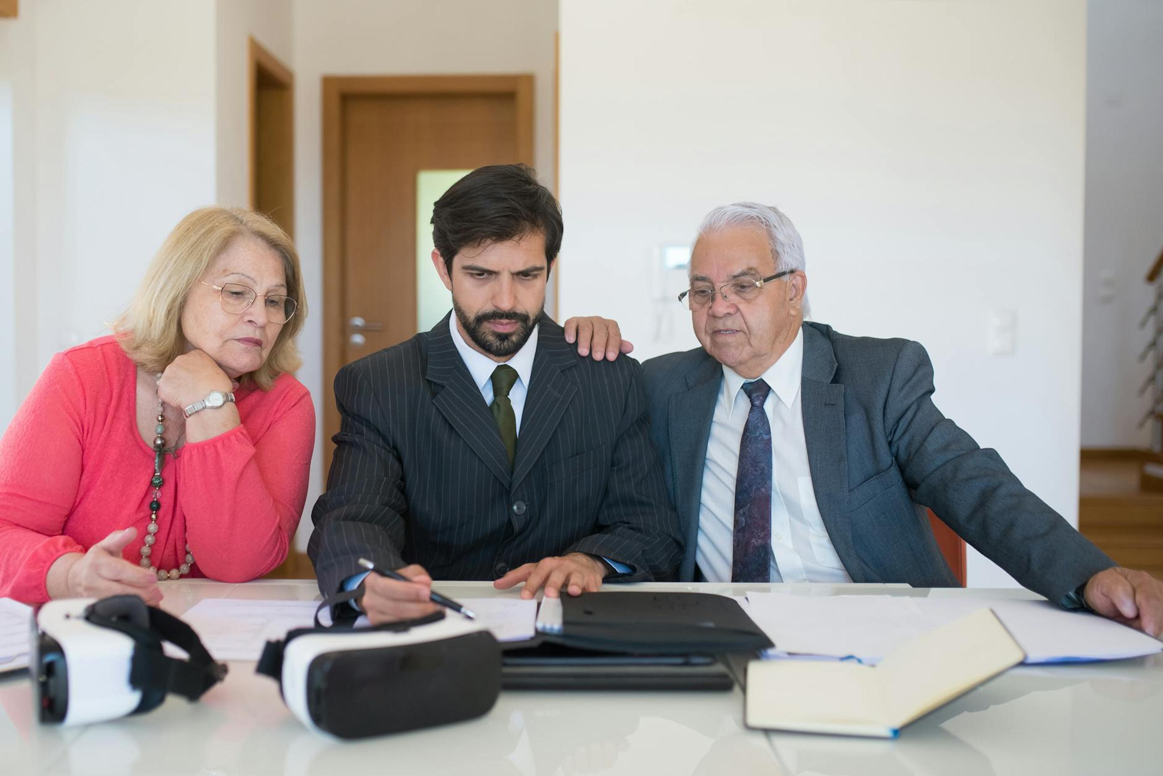 Senior couple in a meeting with a real estate agent discussing property details.