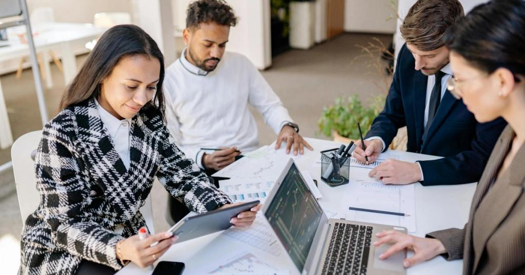 Business team engaged in planning and analysis with laptops and papers at a modern office.
