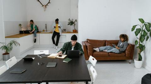 Diverse team working in a modern office, utilizing digital devices for collaboration