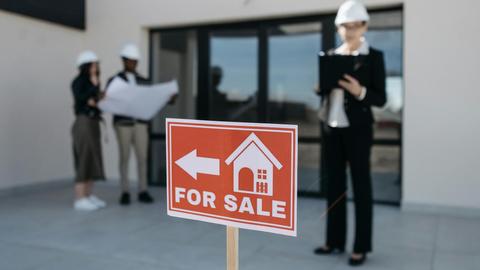 Three real estate professionals inspecting a property for sale with a focus on the business aspect.