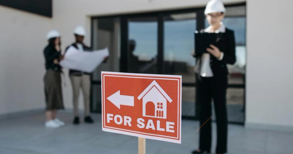 Three real estate professionals inspecting a property for sale with a focus on the business aspect.