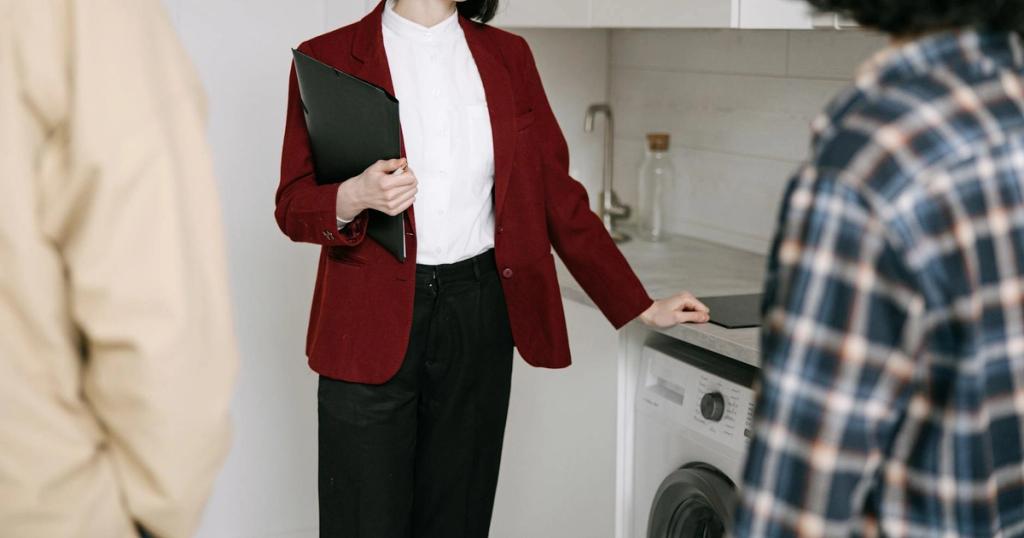 Real estate agent with clients in a modern kitchen during apartment viewing. Professional and engaging.
