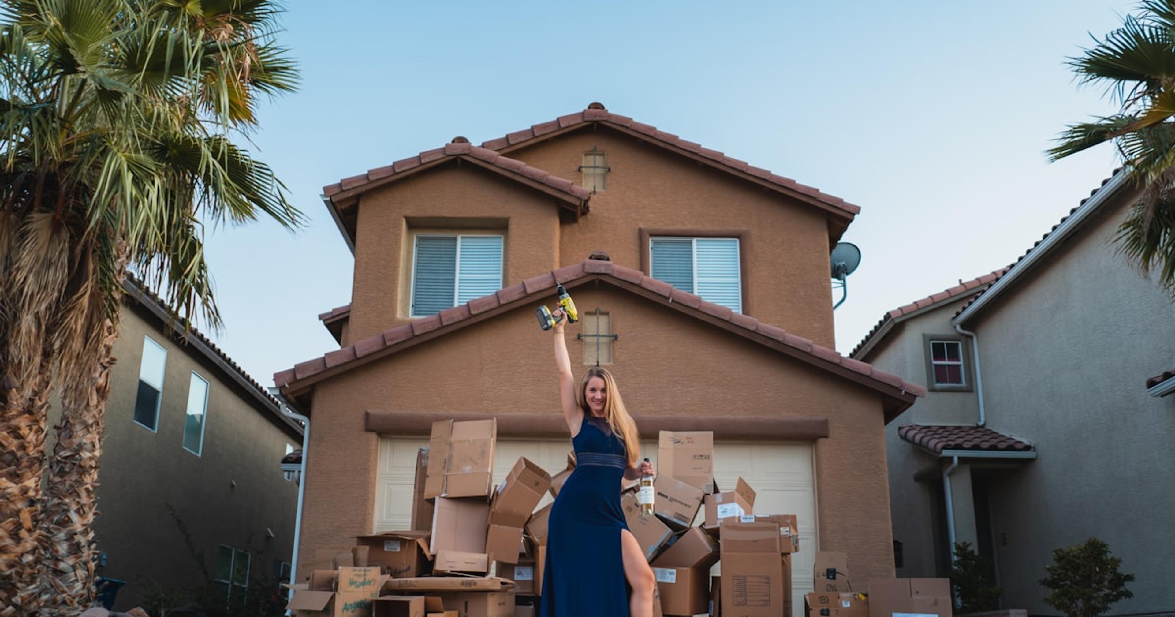 woman in black dress standing near brown concrete building during daytime