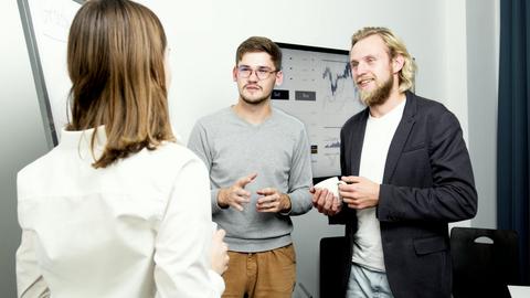 Team of professionals engaging in a lively office discussion about financial data.