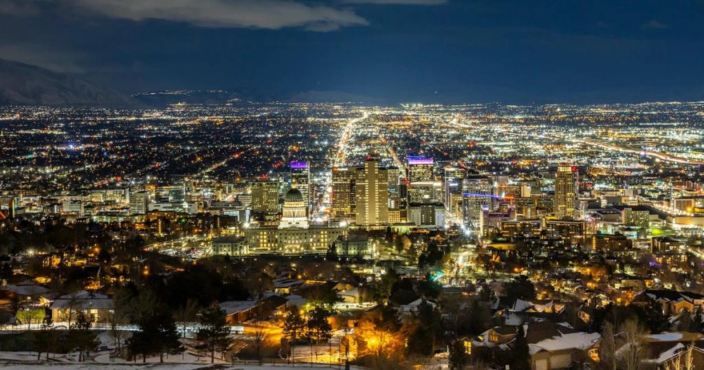 A breathtaking aerial view of Salt Lake City at night featuring a vibrant skyline and illuminated buildings.