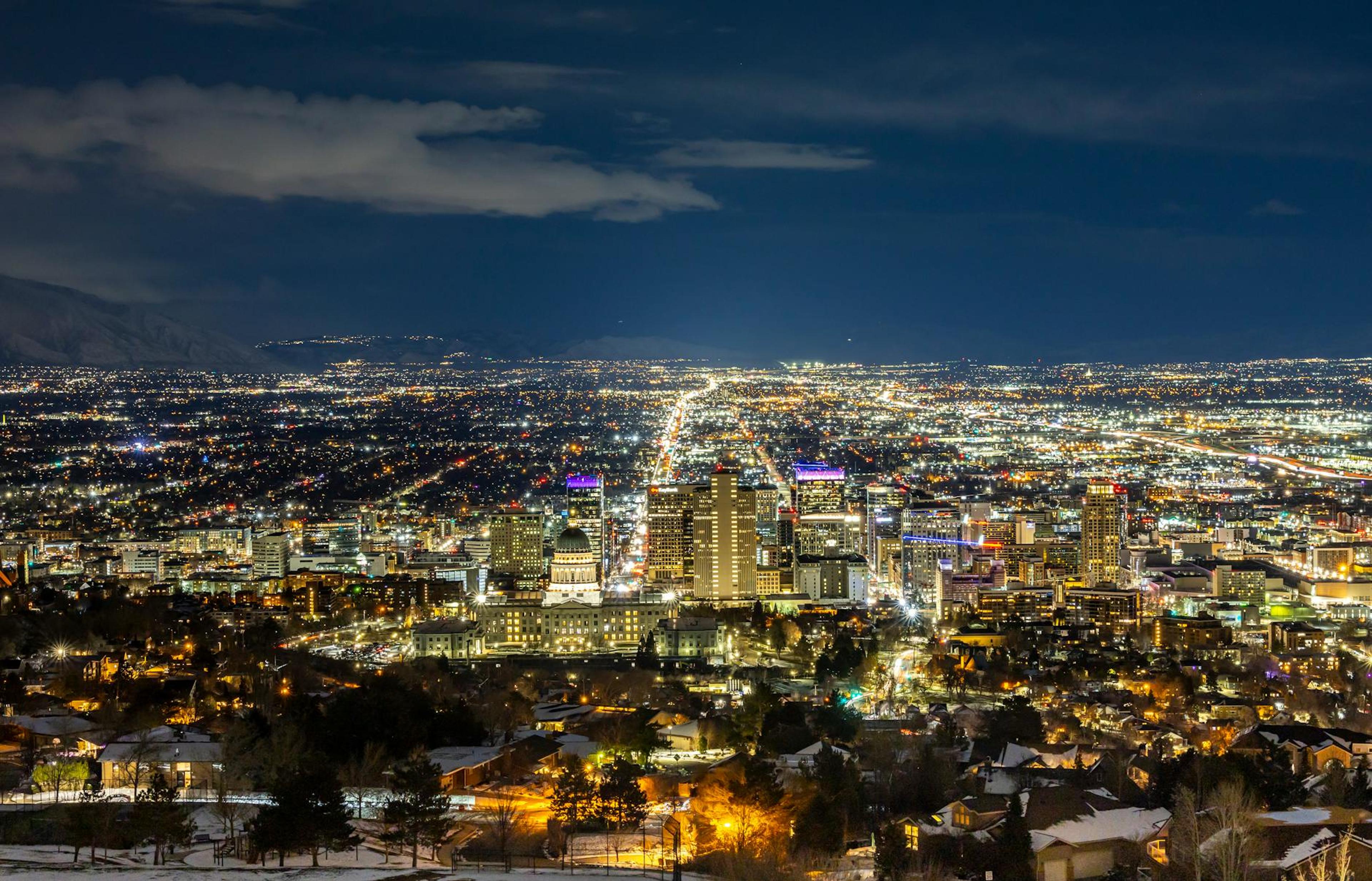 A breathtaking aerial view of Salt Lake City at night featuring a vibrant skyline and illuminated buildings.