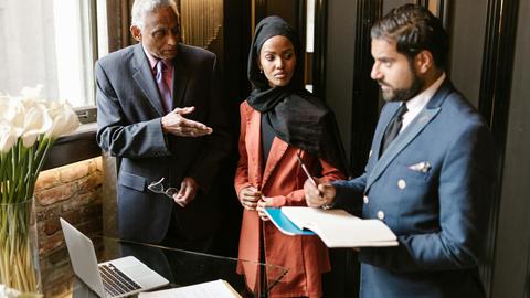 Group of professionals in business attire discussing strategy indoors.