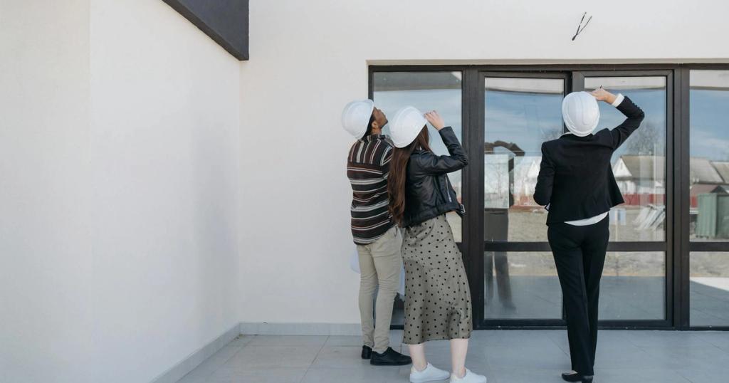 Three architects evaluating exterior building structure, wearing helmets and business attire.