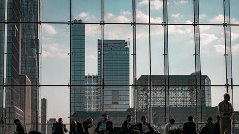 Business professionals at the Javits Center, New York City featuring urban skyline through glass facade.