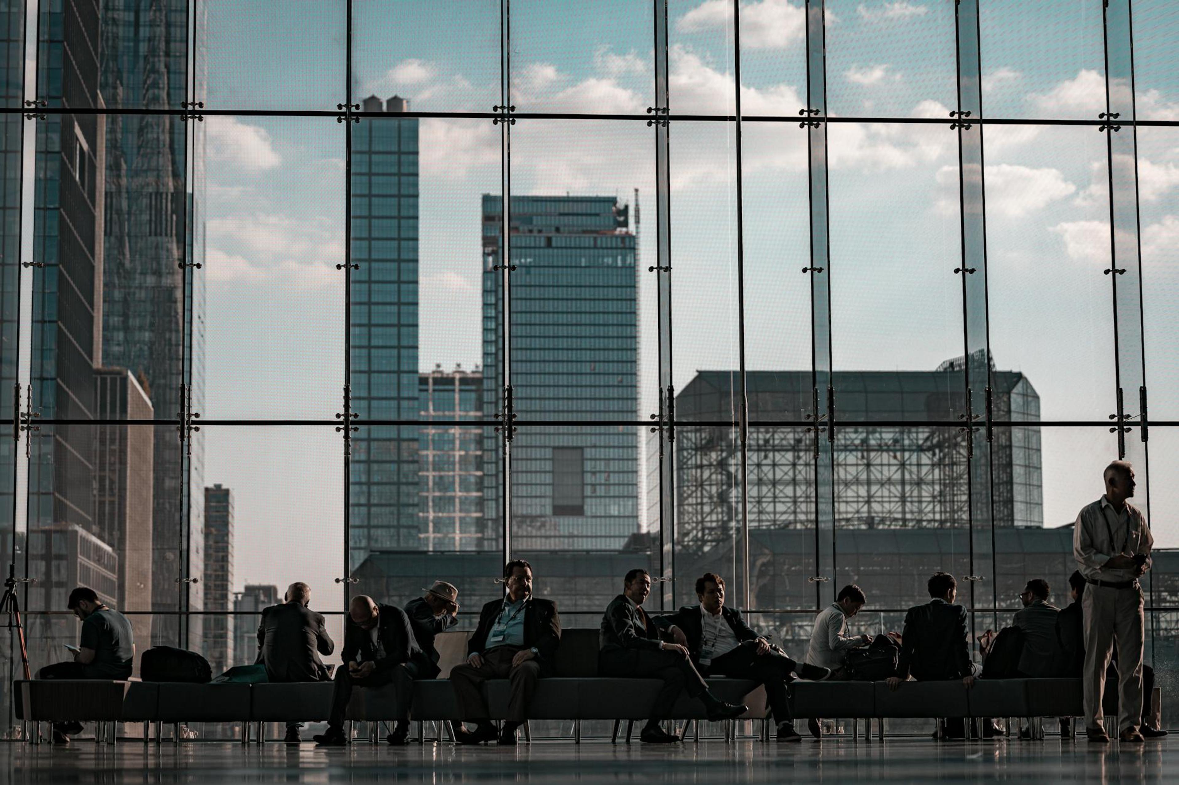 Business professionals at the Javits Center, New York City featuring urban skyline through glass facade.