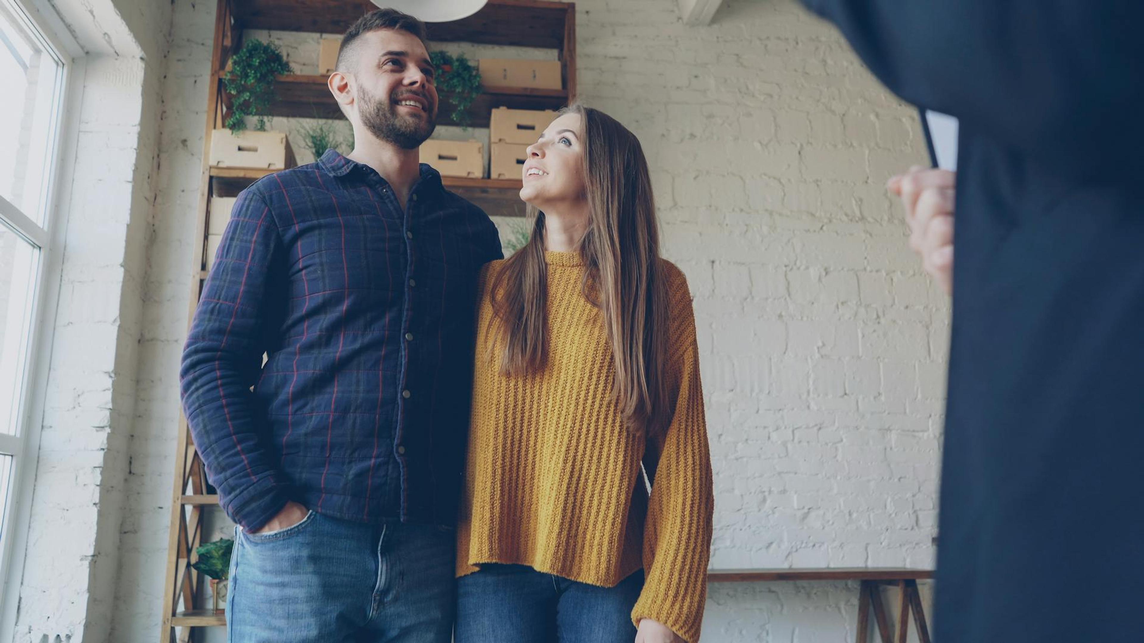 Happy young couple consulting with a real estate agent in a stylish modern home.