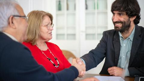 Business professionals engaged in a positive office meeting, sealing a deal with a handshake.