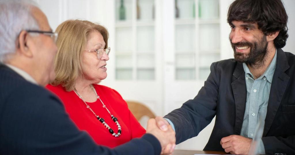 Business professionals engaged in a positive office meeting, sealing a deal with a handshake.