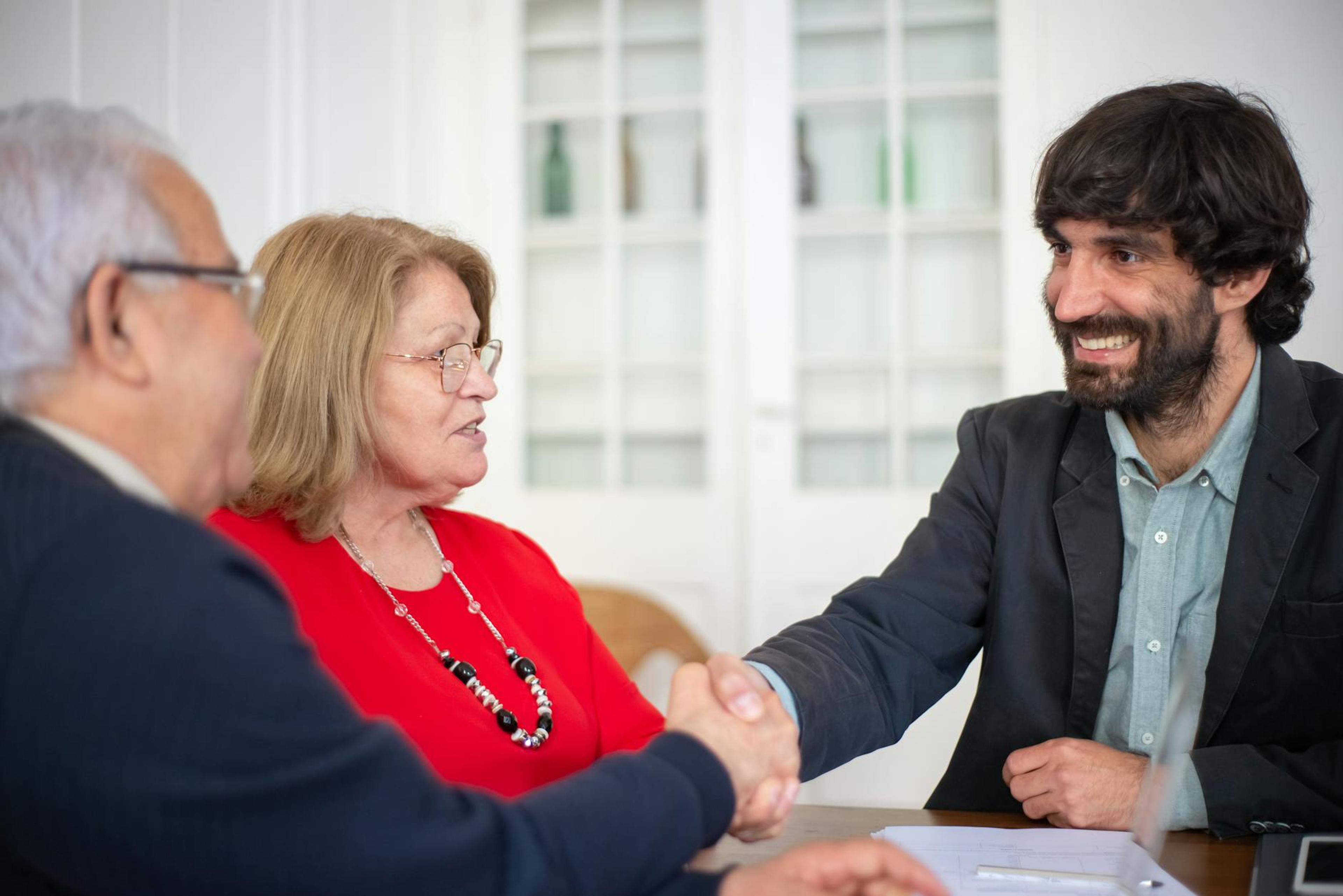 Business professionals engaged in a positive office meeting, sealing a deal with a handshake.