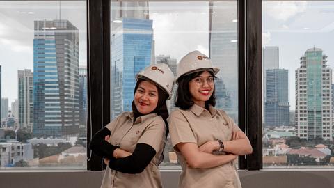 Two women in hard hats and uniforms