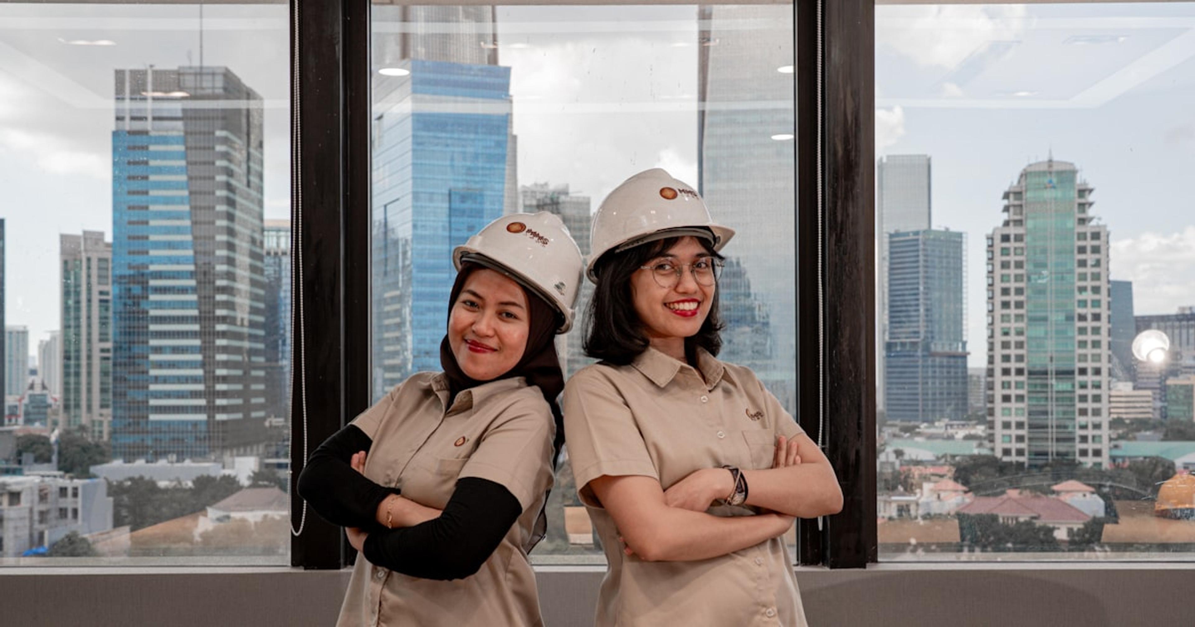 Two women in hard hats and uniforms