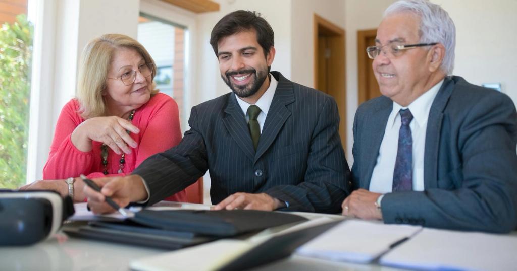Professional realtor discussing real estate deal with senior couple in bright office setting.