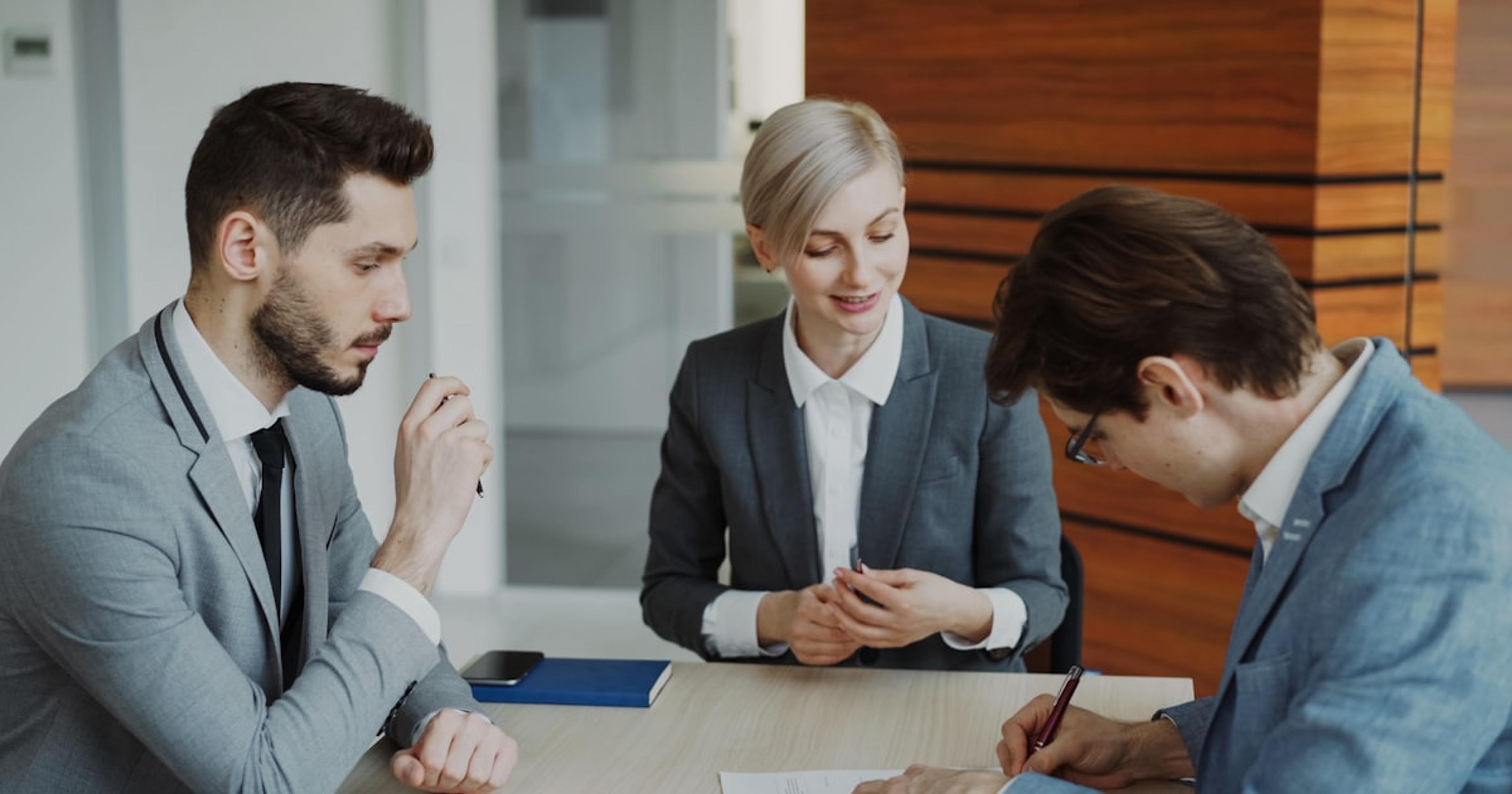 Business people signing a contract at a table.