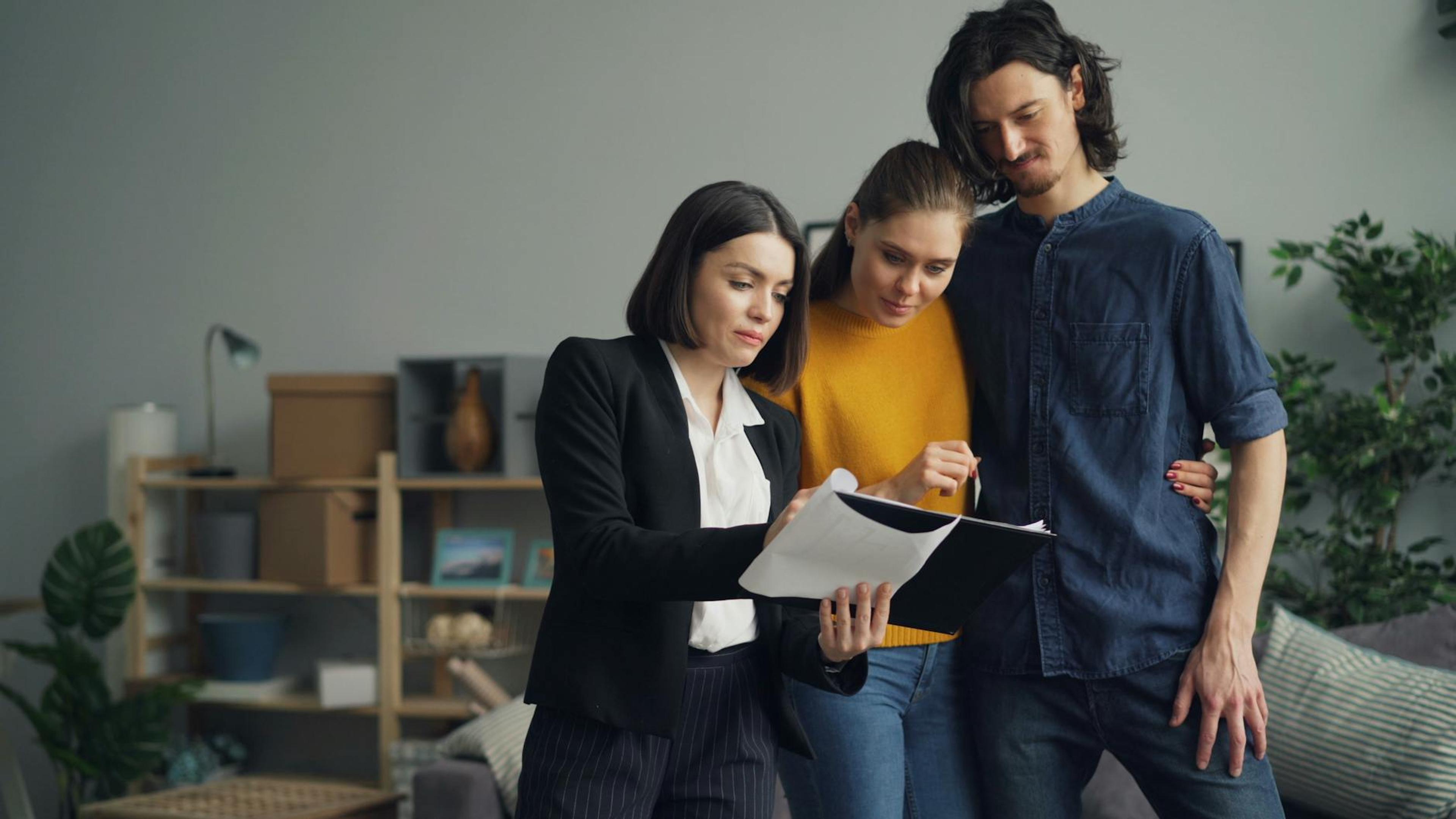 Young couple consulting with a real estate agent about property one indoors.
