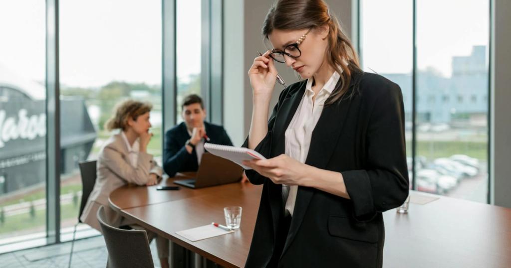 Confident woman reviewing notes leading a business meeting in a modern office setting.