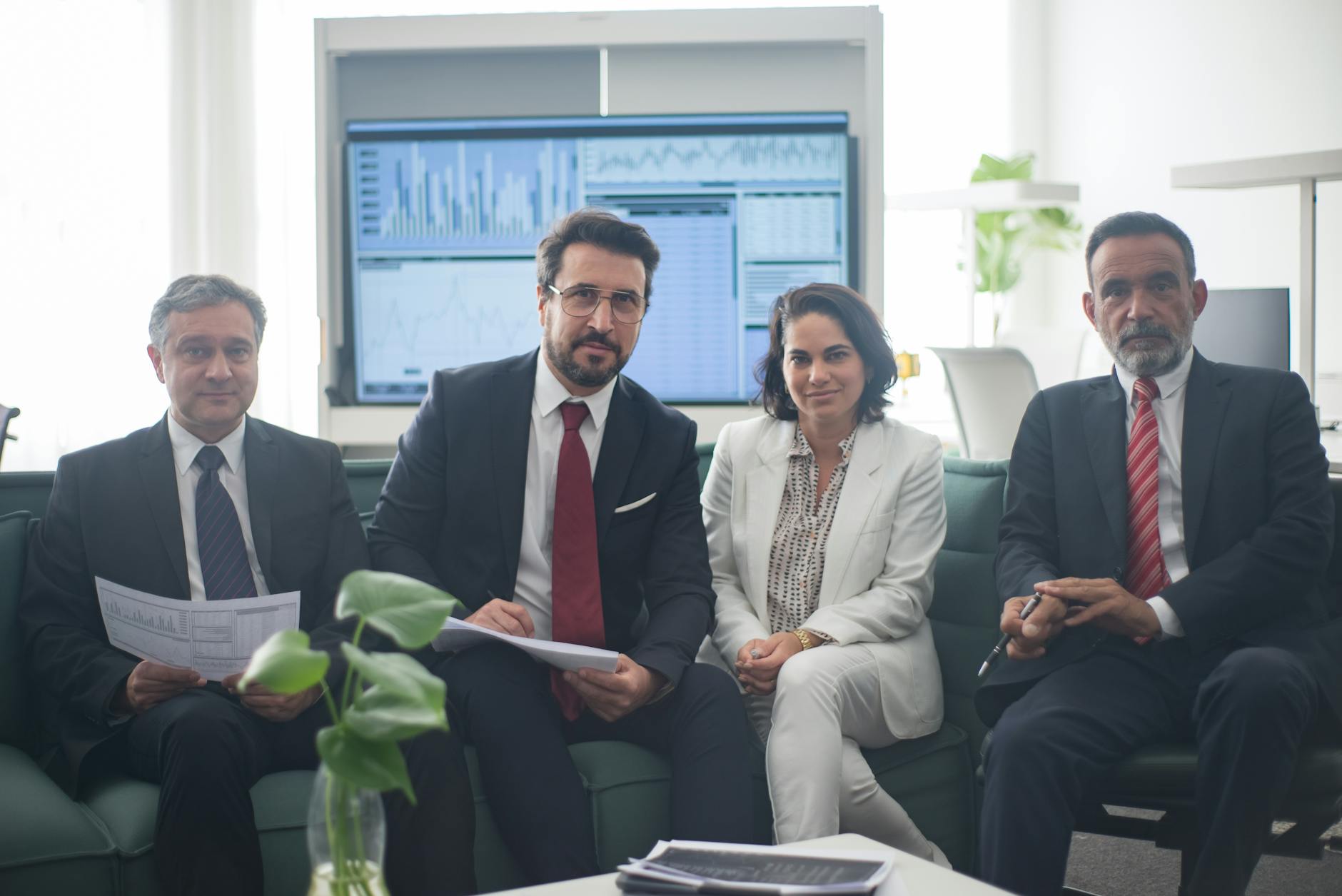 Professional team in corporate attire ready for a meeting, engaged in discussion.