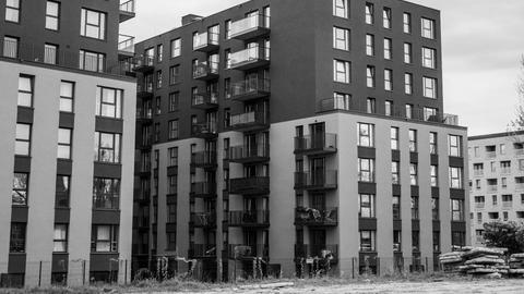 Stylish urban apartment buildings with balconies in grayscale tones, focusing on modern architecture.