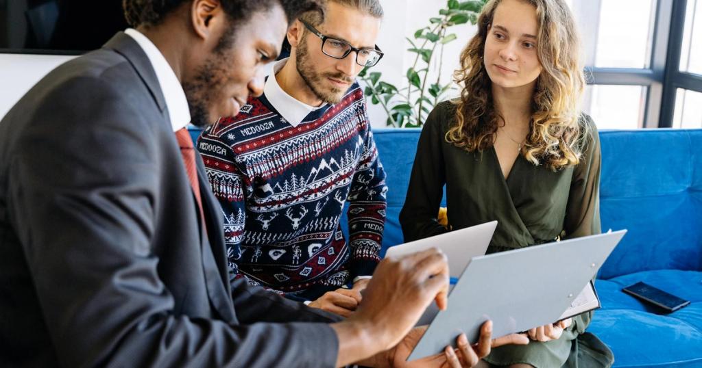 A diverse group of young professionals engaged in a business meeting inside a modern office.