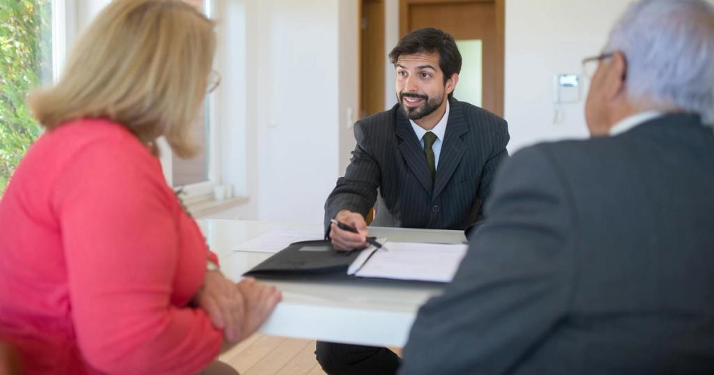 A real estate agent discussing a deal with senior clients in an office setting.