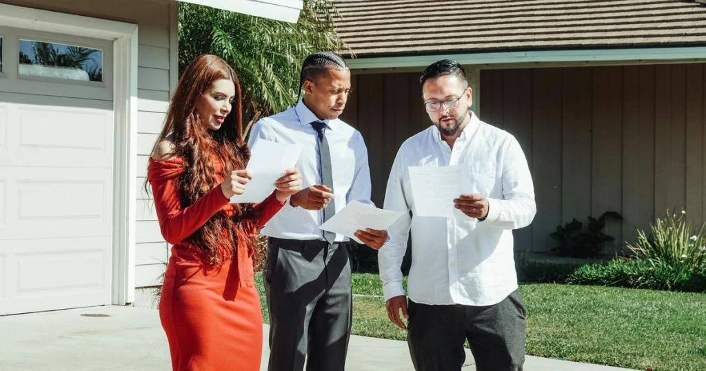 A group of adults reviewing real estate documents outside a house on a sunny day.