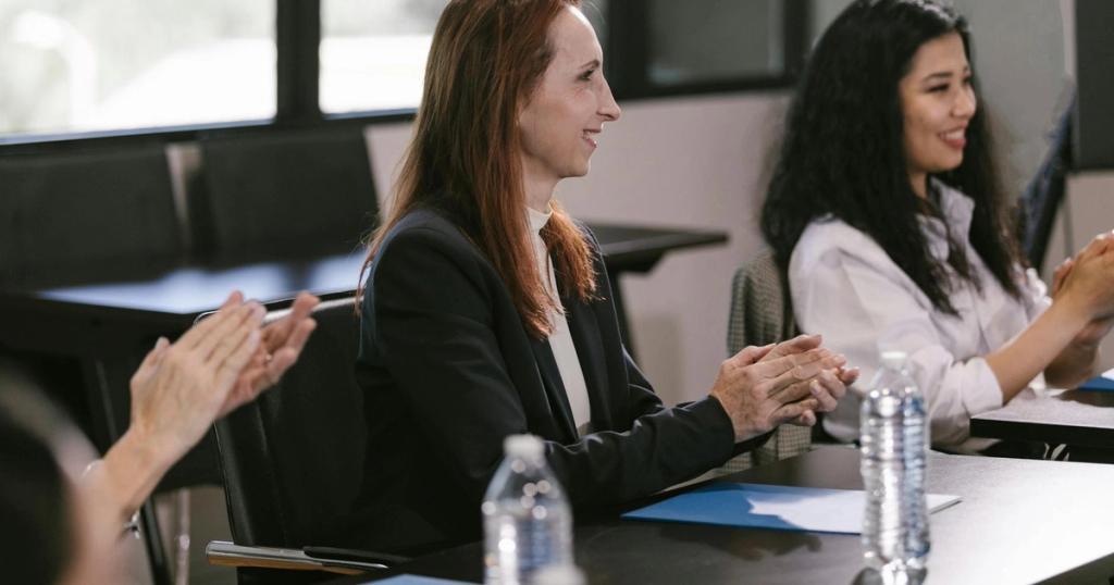 Business professionals engaged in a positive meeting, clapping in appreciation.