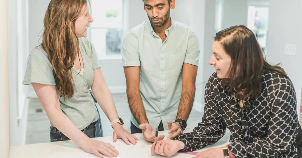 Three adults having a discussion about real estate in a modern home setting.